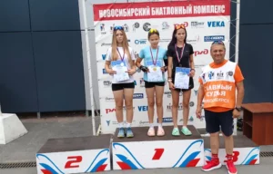 Награждение призёров соревнований по биатлону на пьедестале с медалями и дипломами